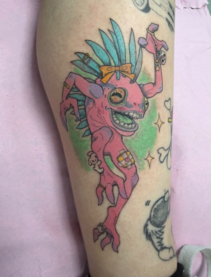 Tatuaje a color de un ajolote rosa kawaii con lazo naranja