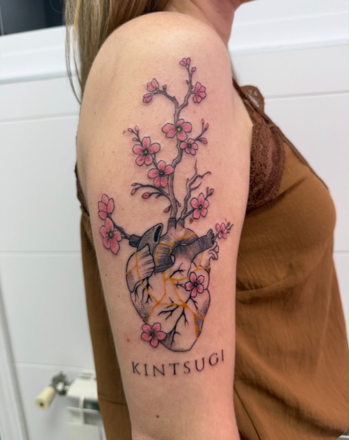 Tatuaje de corazón anatómico kintsugi con flores de cerezo